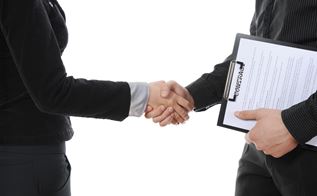 Håndtryk mellem 2 forretningsmænd, hvor den ene holder et dokument under sin arm. Isoleret på hvid baggrund. Kilde: Colourbox