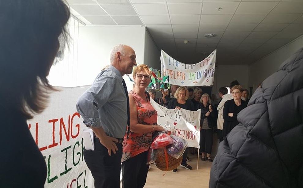 Dagplejere og forældre i skive kommune overrækker lapper til borgmesteren, har medbragt bannere som protest mod besparelser