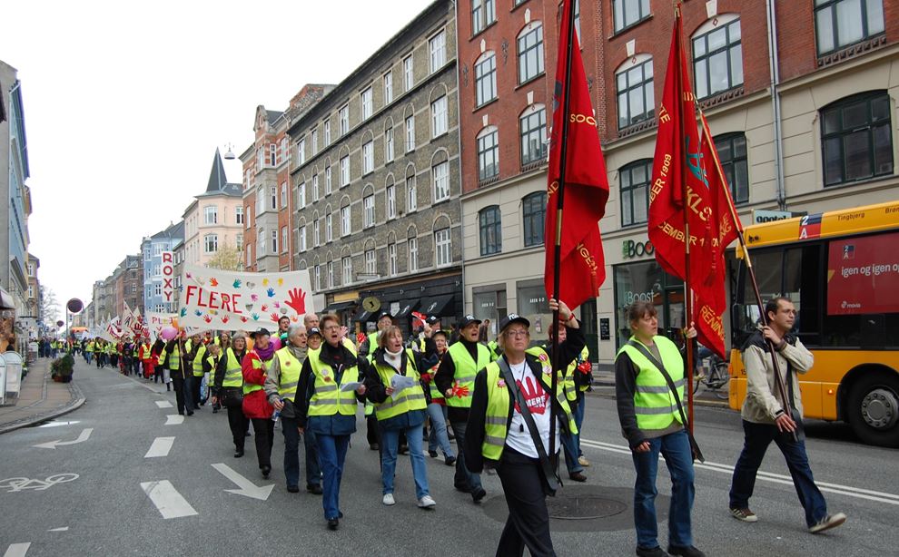 Folk marcherer med røde faner 1. maj