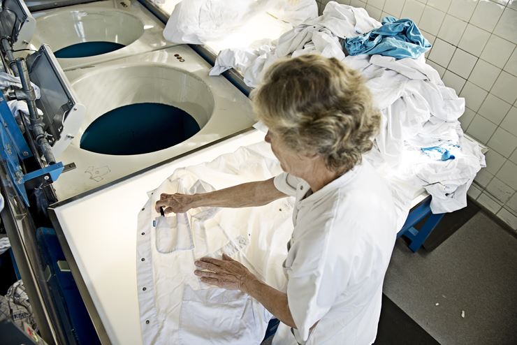 En kvinde lægger en hvid skjorte på en oplyst plade