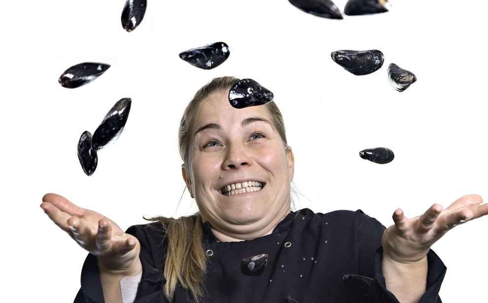 En kvinde kaster en masse muslinger op i luften