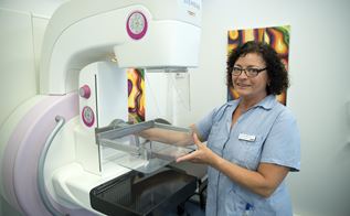 Kvindelig sosu-assistent betjener udstyr til mammografi