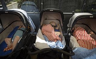 Tre børn sover i barnevogne