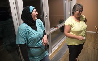 To kvindelige sosu-hjælpere står og griner