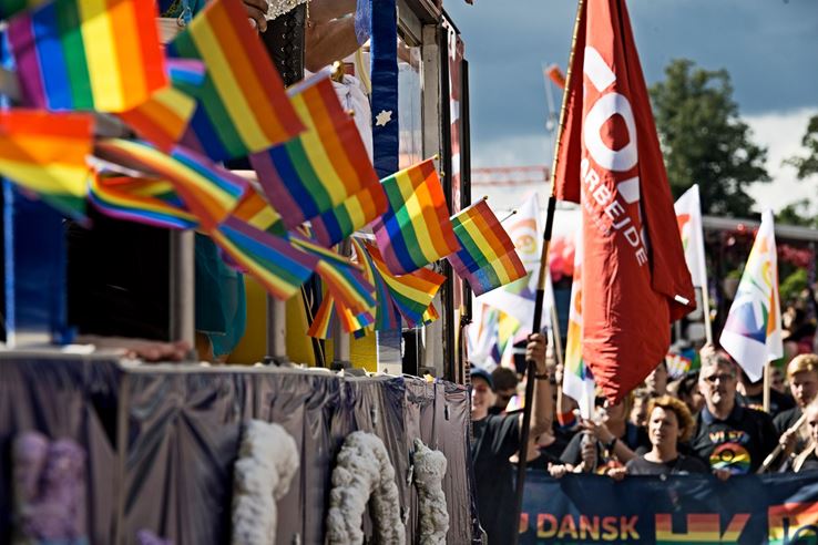 Regnbueflag og røde faner ved FOA's deltagelse i Pride Parade 2017