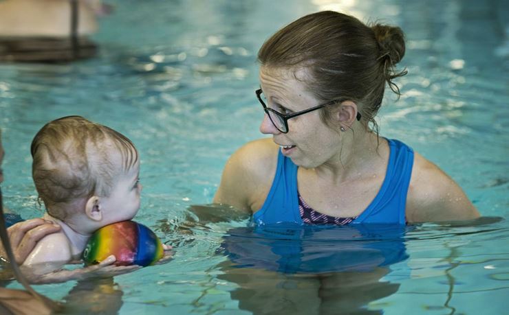 Instruktør har øjenkontakt med barn til babysvømning