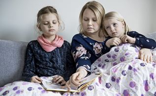 En mor læser bog for sine to døtre