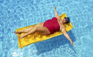 Overvægtig kvinde flyder på en luftmadras i en pool