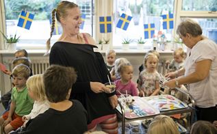 Pædagogisk personale uddeler svenske snacks i tema uge om Sverige
