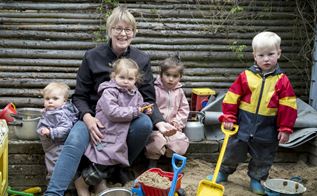 Dagplejer Margit Nielsen med børn i sandkasse