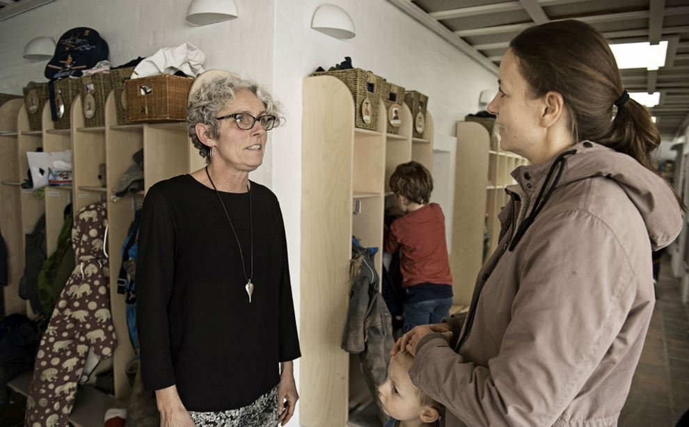 Pædagog Heidi Nielsen taler med en mor i garderobe