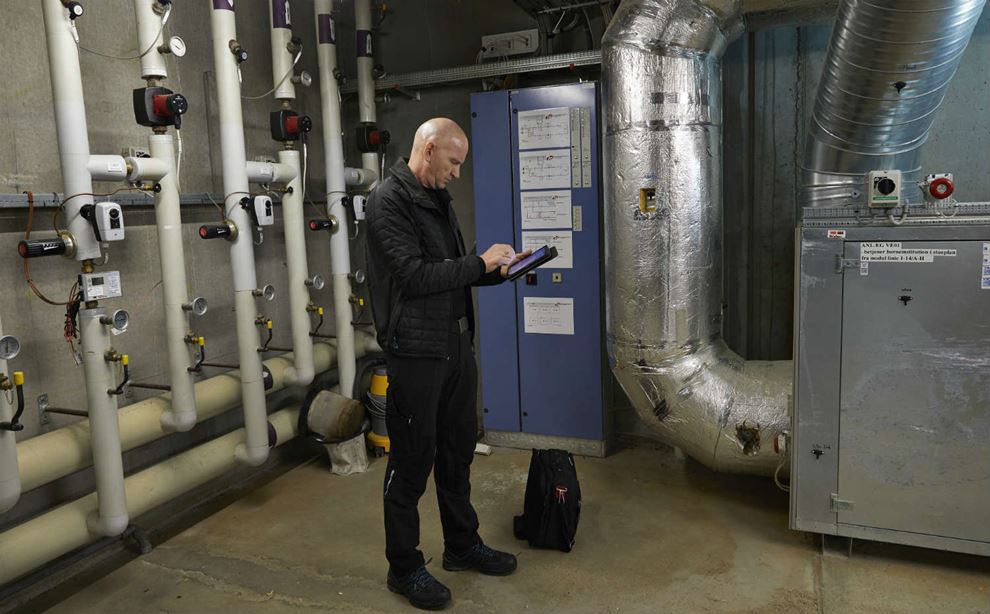 Ejendomsservicetekniker Claus Rod står i rum og styre klimaet på skole i Silkeborg kommune.
