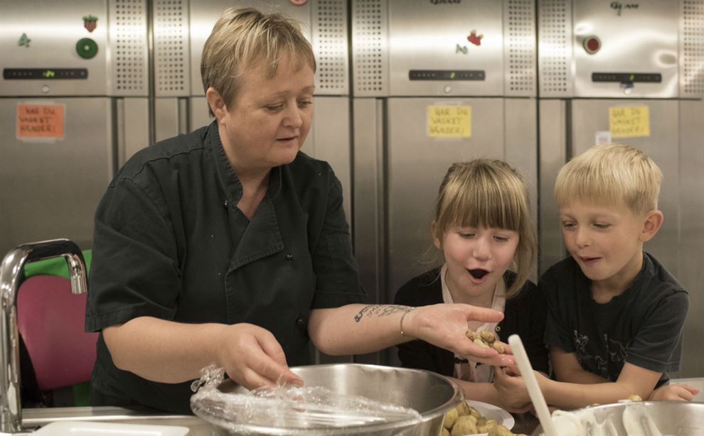 Køkkenleder laver mad med to børn