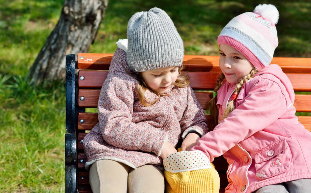 To børn leger på en bænk