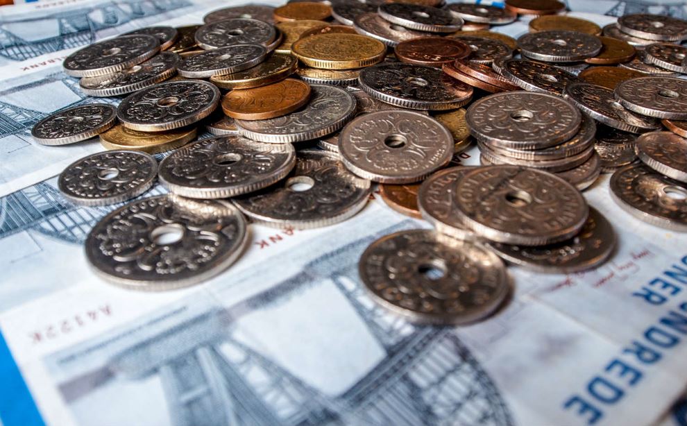 Mønter lagt ovenpå et lag af pengesedler