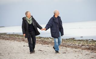 Ældre par går tur ved stranden