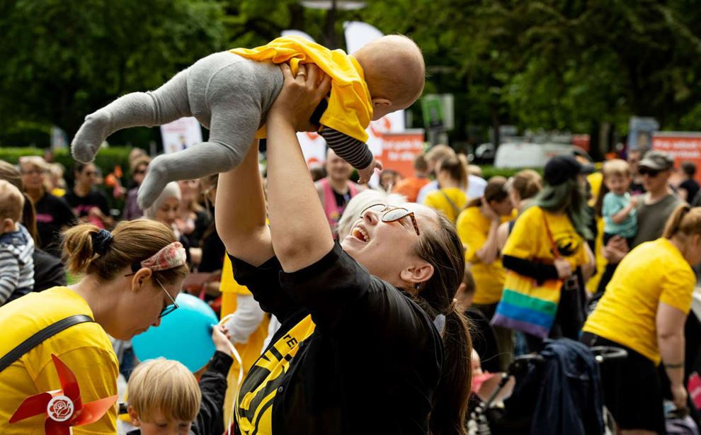 En kvinde løfter en baby til en demonstration