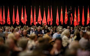 Foto fra salen til FOAs kongres 2019 med røde faner i baggrunden