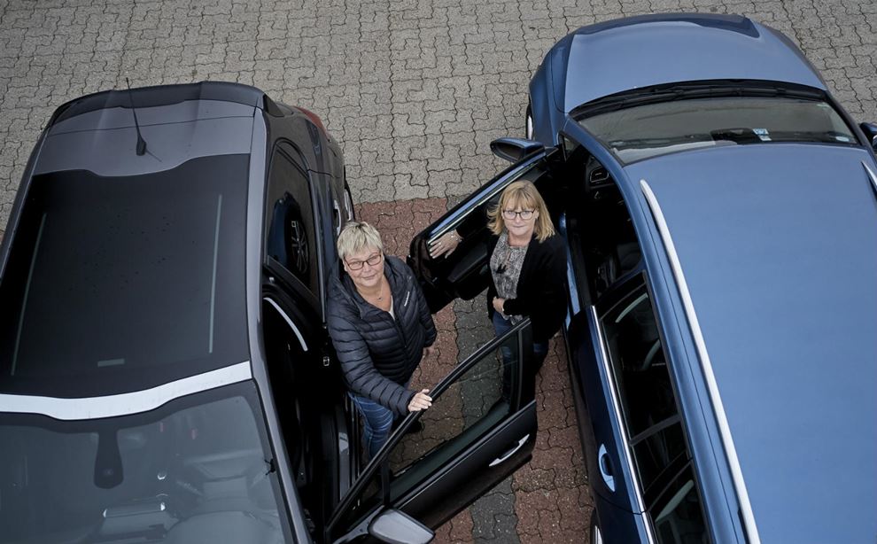 To kvinder står mellem to biler