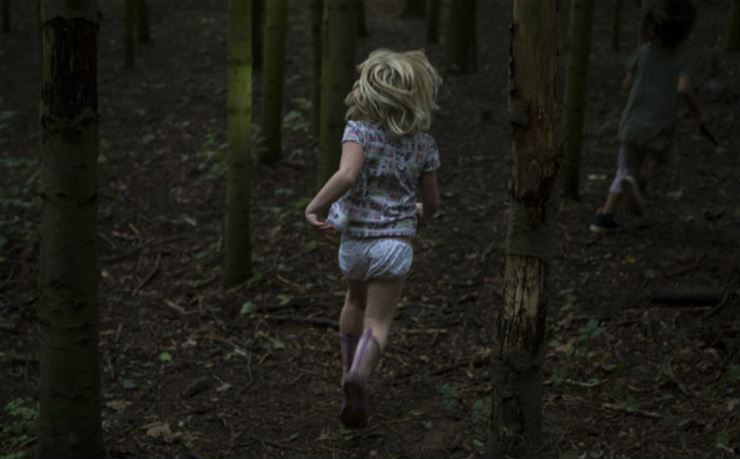 Barn løber i mørk skov