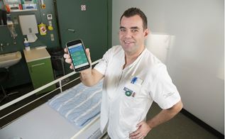 Serviceassistent Christian Olsen viser det nye system frem på smartphone