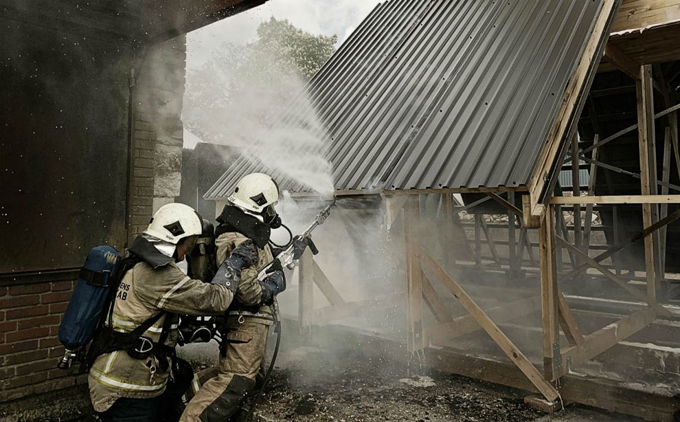 To brandmænd slukker brand i øvelse