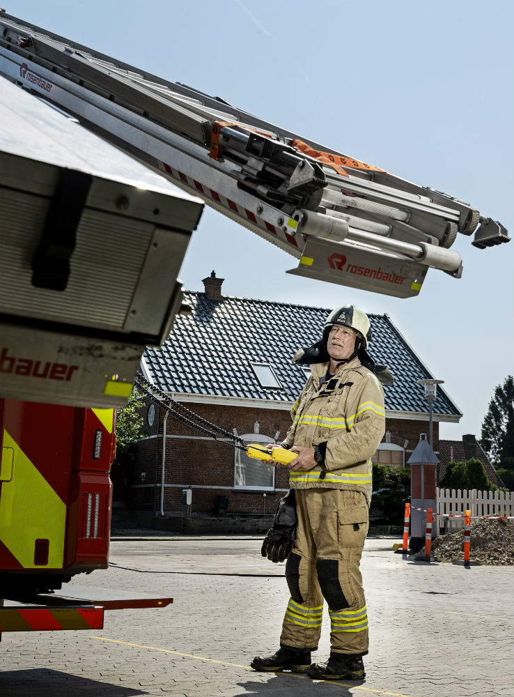 Brandmand står foran elektrisk stigegalleri på brandbil