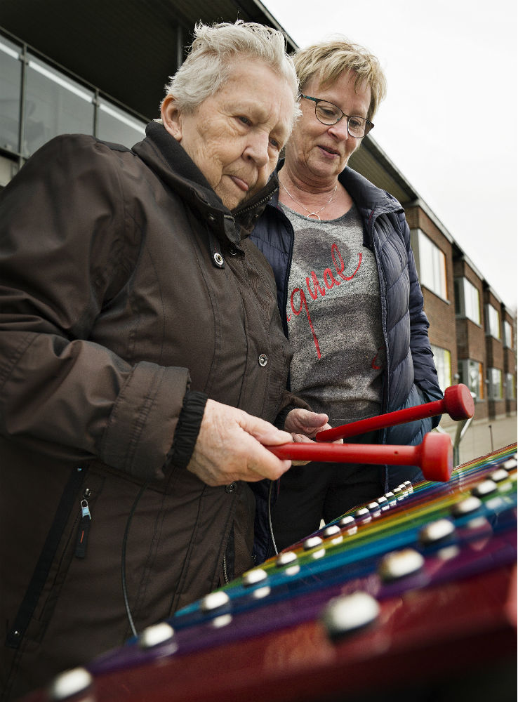 Ældre dame spiller xylofon med hjælp fra sosu-assistent