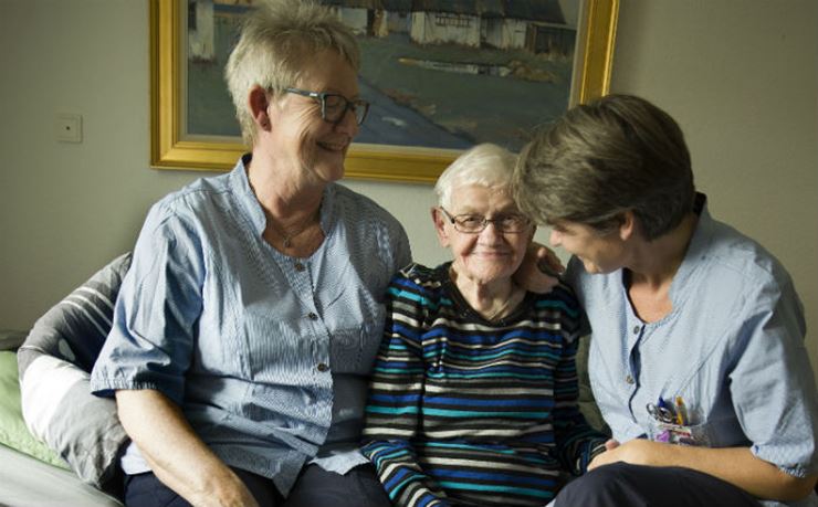 To social- og sundhedshjælpere krammer ældre beboer for at forebygge hudsult