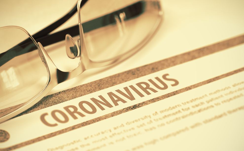 Et par briller ligger ovenpå en attest vedrørende coronavirus