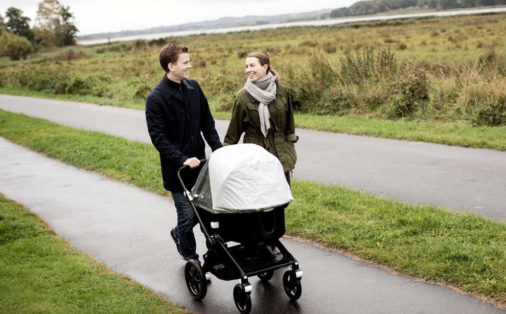 Thomas og hans hustru går tur med barnevognen i naturen