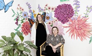 To kvinder foran en blomstret væg. Foto: Tor Birk Trads
