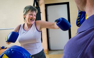 Kvinde med boksehandsker i gang med fysisk træning
