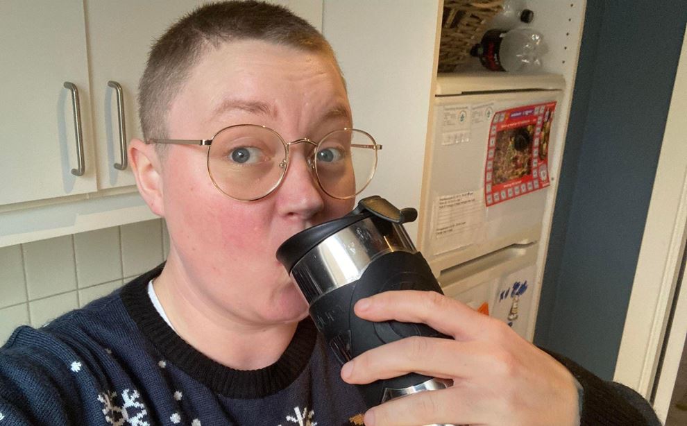 Kvinde drikker kaffe af termokande