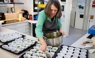 Husassistent Marian Pedersen er i gang med at fylde muffinsforme med broccoli 