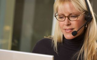 Kvinde taler i telefon med en computer foran sig