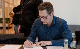 Thomas Brücker skriver under på den nye overenskomst for dem, der er ansat i en kommune. (Foto: Rasmus Breum)