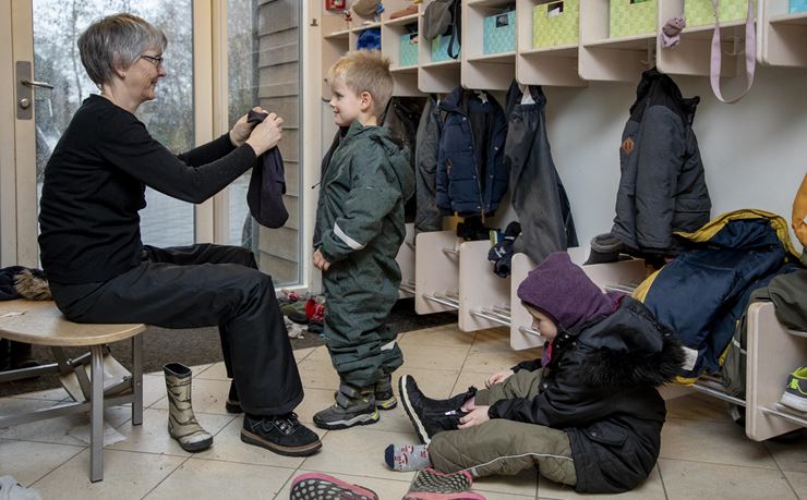 I Børnehuset Sund - brinkens garderobe hjælper pæ - dagogisk assistent Ina Henriksen ø-børnene med at blive klar, inden turen går mod færgen. 