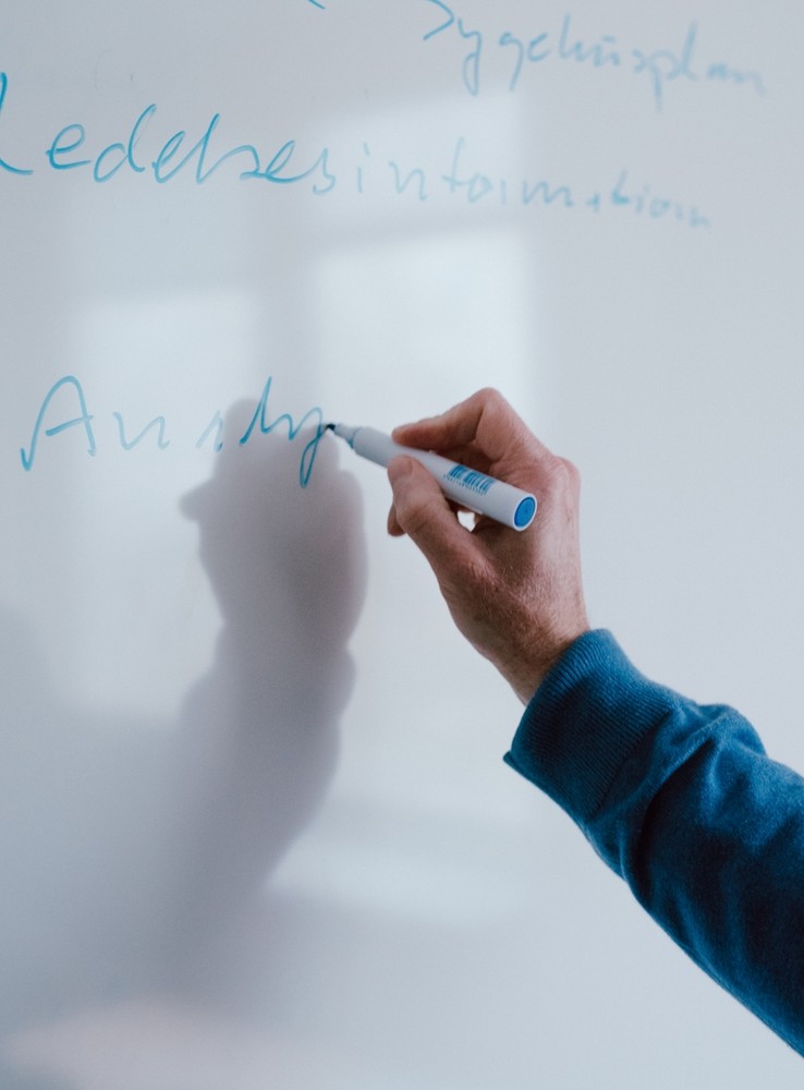 Hånd skriver med tus på whiteboard